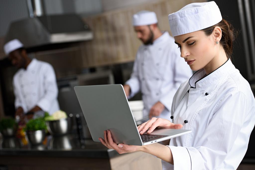 beau chef utilisant ordinateur portable au restaurant cuisine
 - Photo, image