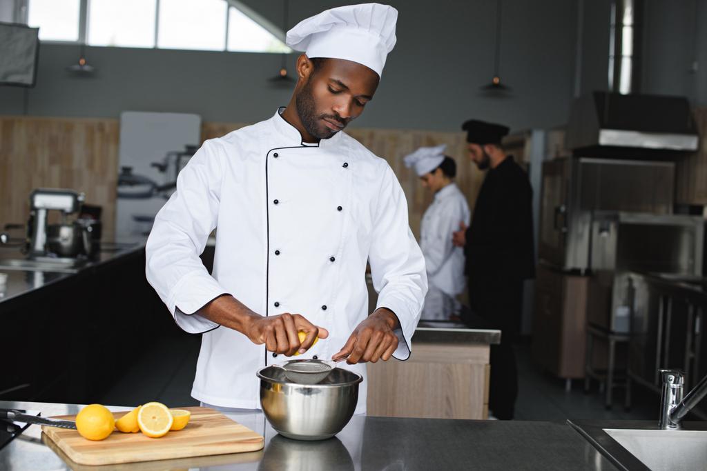 Afryki amerykański chef wyciskania cytryny w restauracji kitchen - Zdjęcie, obraz