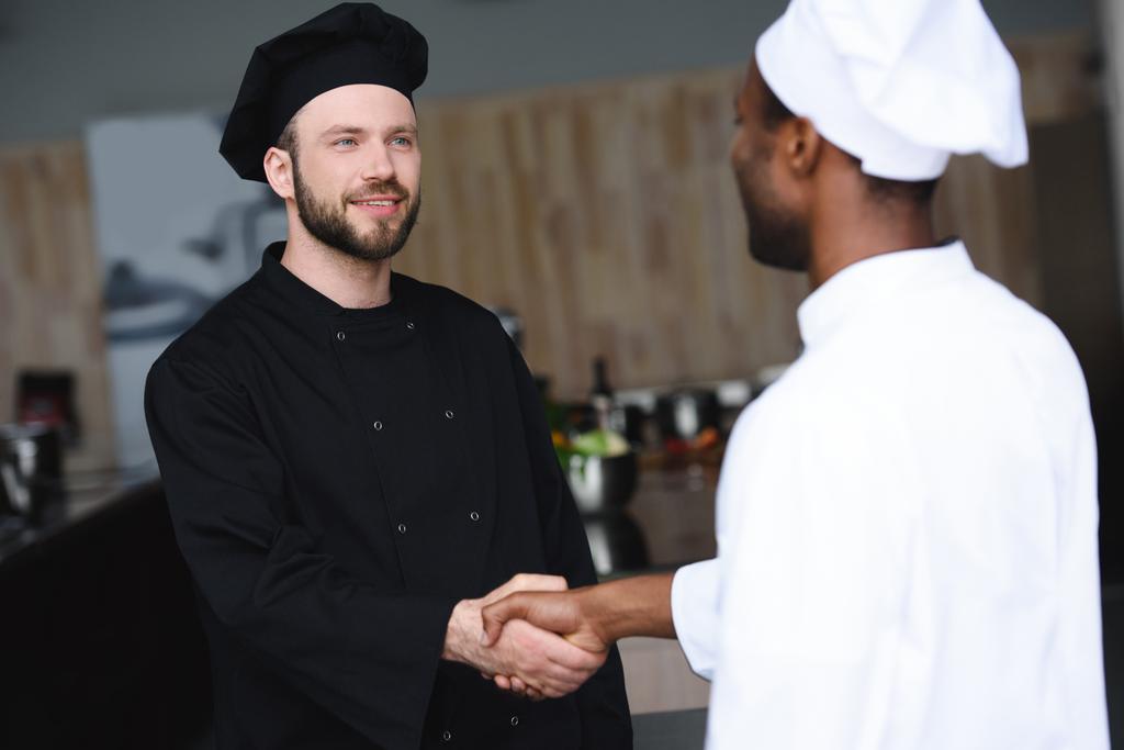 chef multiculturali che stringono la mano alla cucina del ristorante
 - Foto, immagini