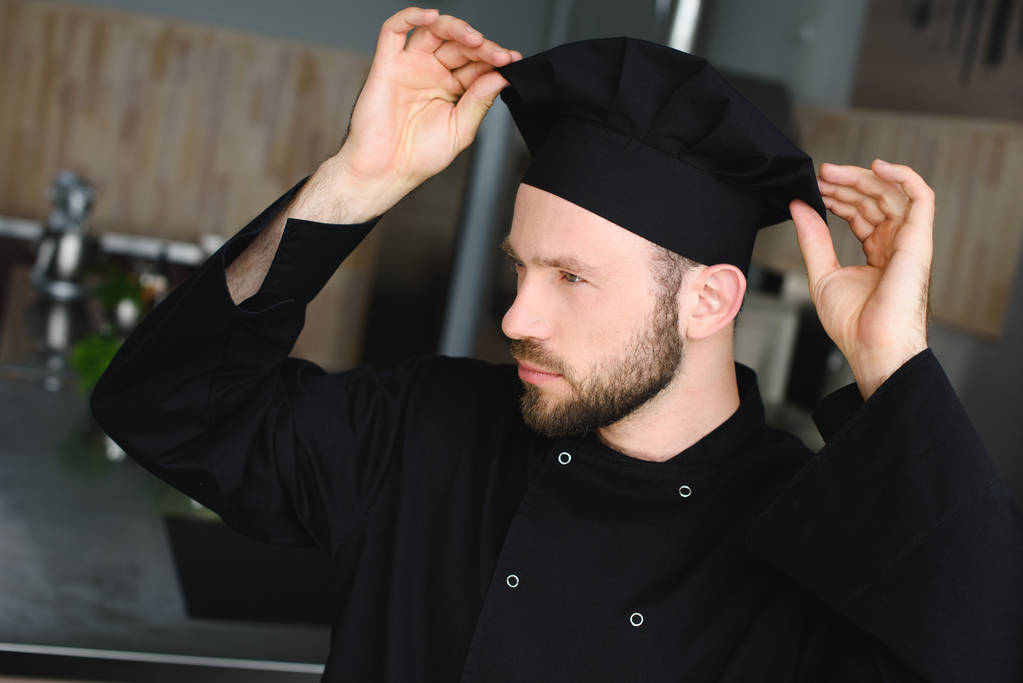 gutaussehender Koch mit Hut in Restaurantküche - Foto, Bild