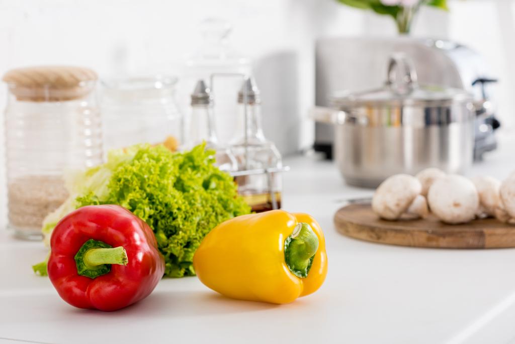 red and yellow bell peppers and green lettuce in kitchen - Photo, Image