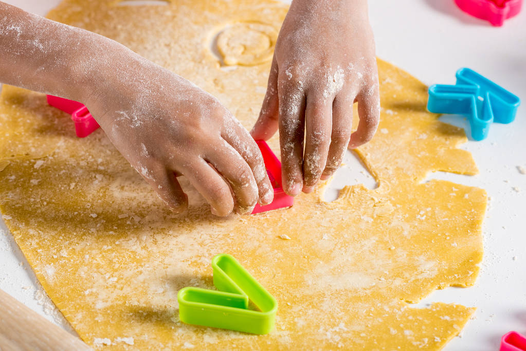 частичный взгляд на африканского американского ребенка, делающего печенье с буквами резак
 - Фото, изображение