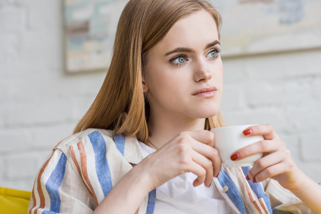 Młoda atrakcyjna kobieta siedząc z filiżanką kawy  - Zdjęcie, obraz