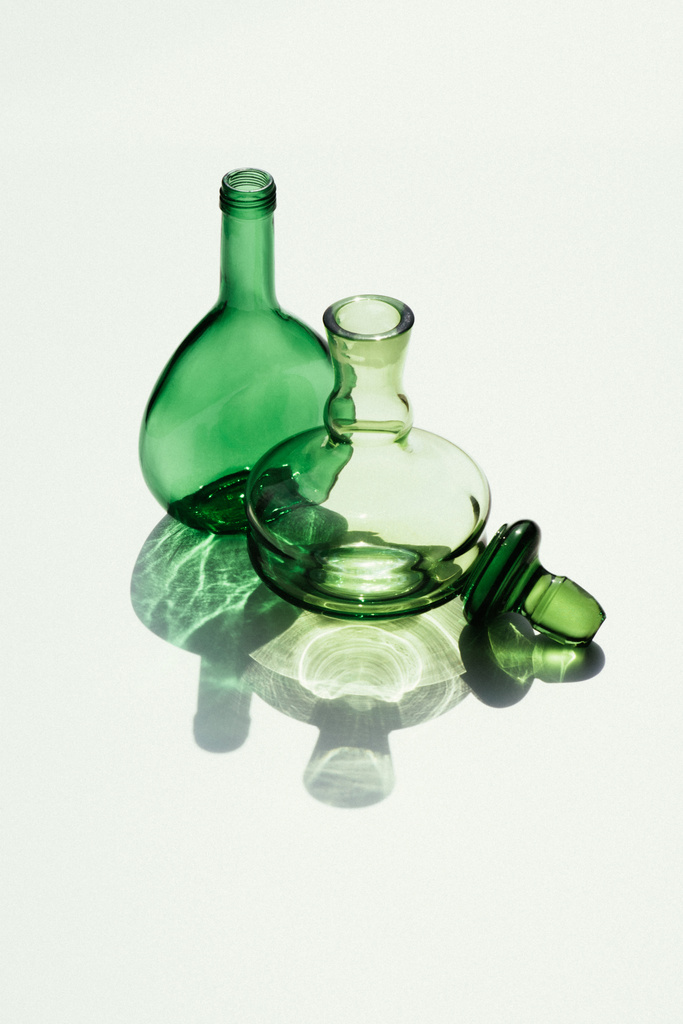 vista de perto de garrafas de vidro vazias e cortiça no fundo branco
 - Foto, Imagem