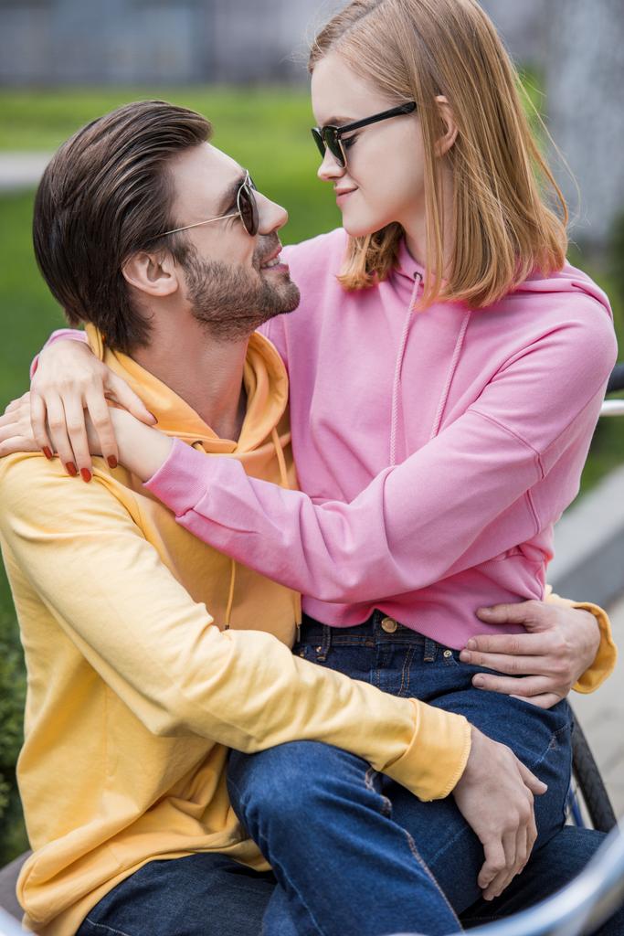 homem em óculos de sol abraçando namorada elegante em óculos de sol
  - Foto, Imagem