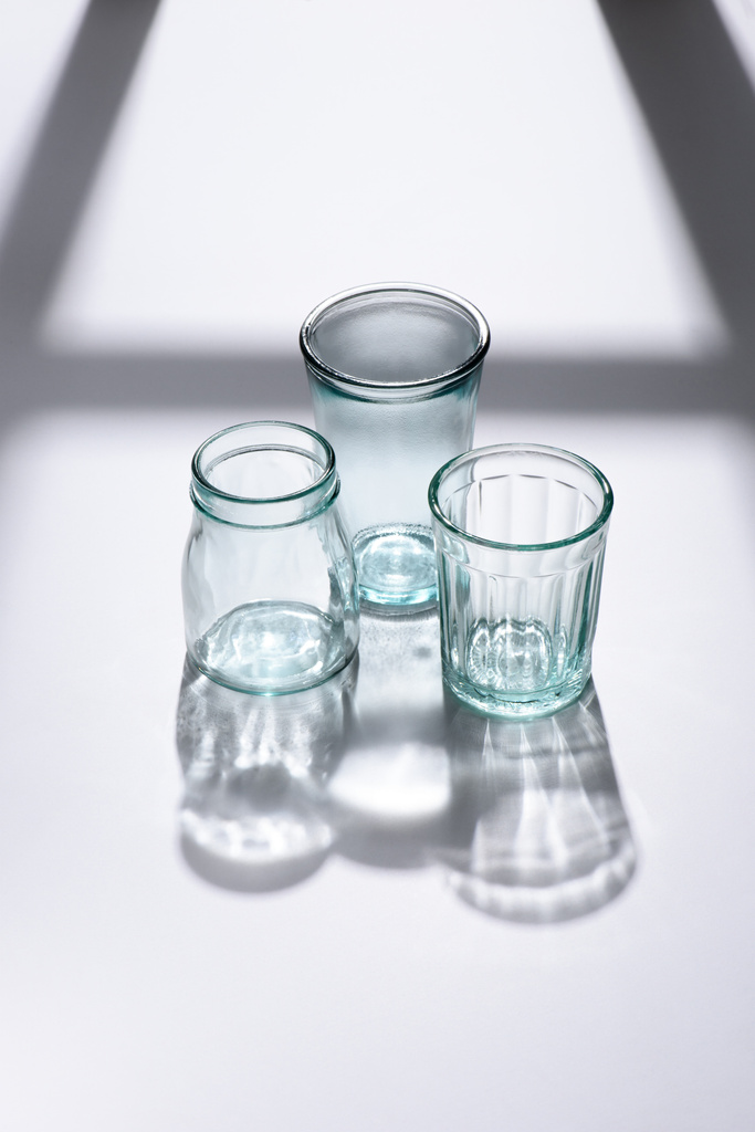 закрыть вид пустой стеклянной посуды на белой поверхности
 - Фото, изображение