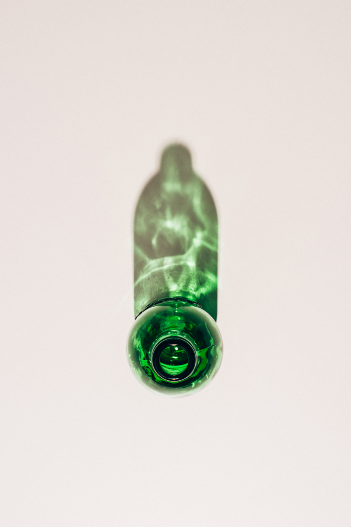 top view of empty green glass bottle with shadow on white tabletop - Photo, Image