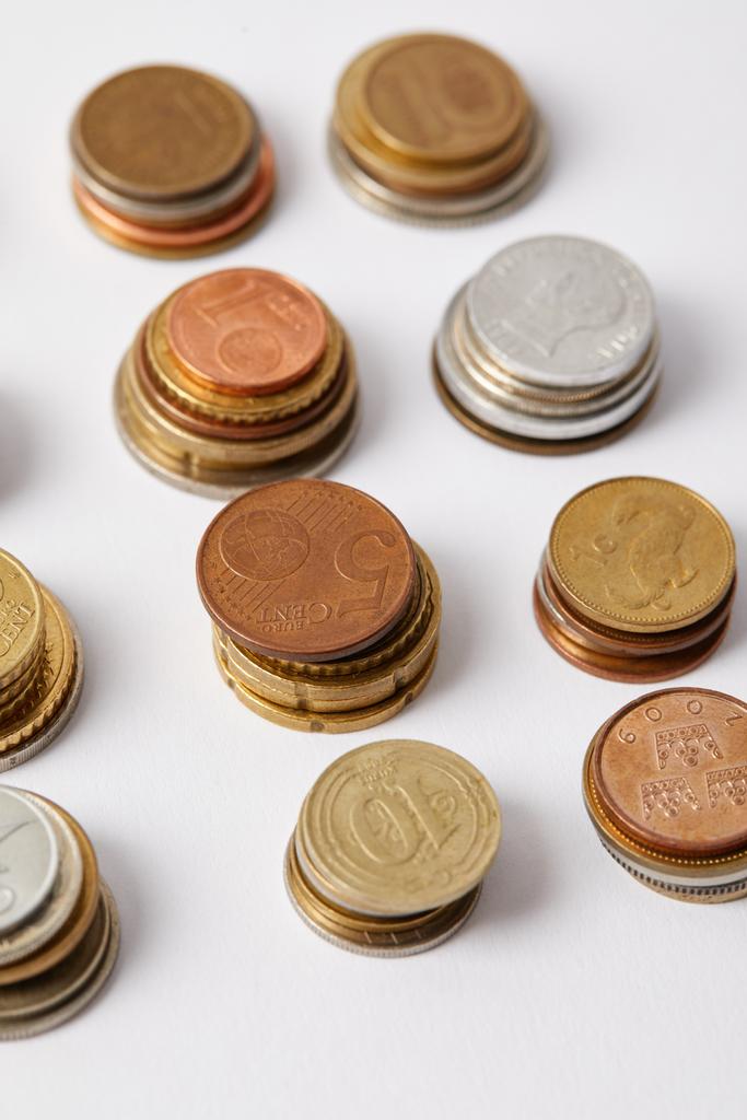 primer plano de pilas de diferentes monedas en blanco
 - Foto, Imagen