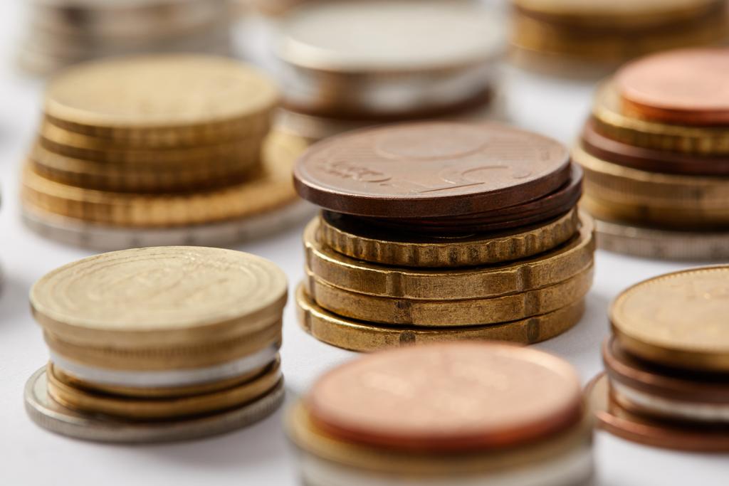 Nahaufnahme von Stapeln von Münzen aus verschiedenen Ländern auf weiß - Foto, Bild