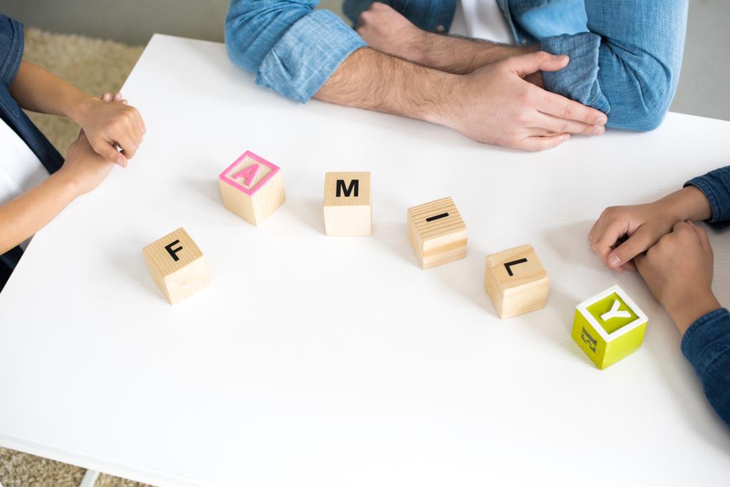 close-up view of cubes with word family and hands of father with kids - Photo, Image