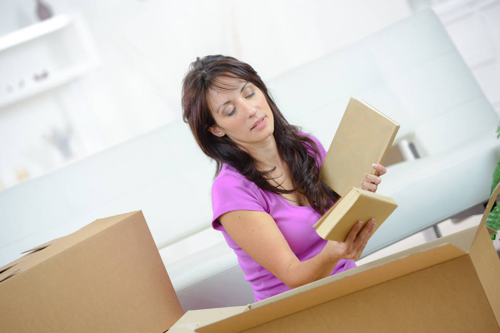Woman packing books into cardboard box - Photo, Image