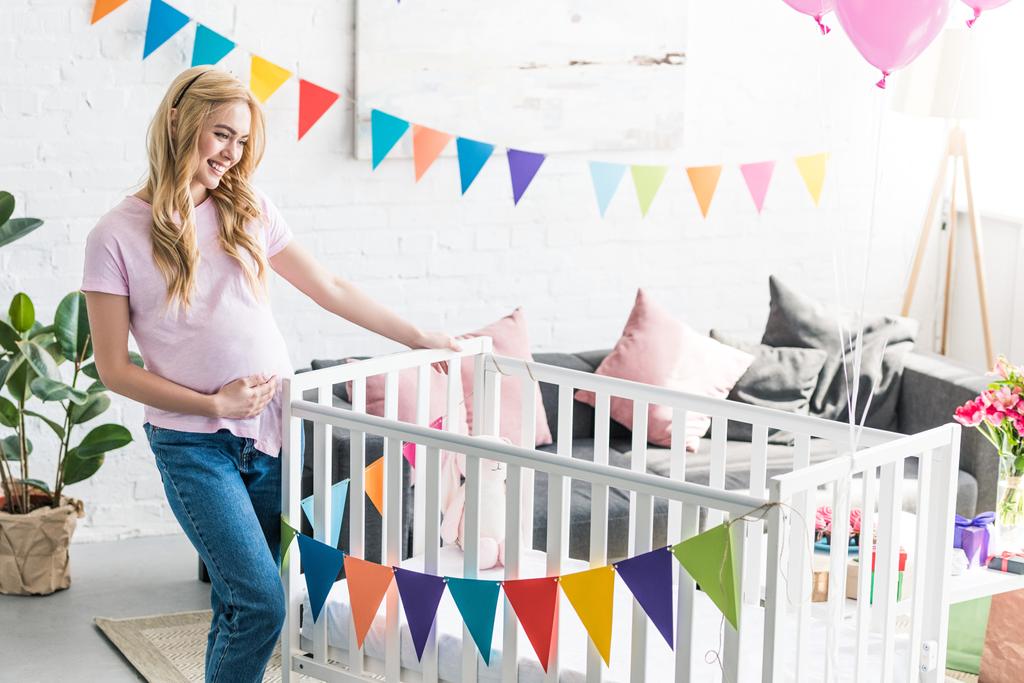 Schöne Schwangere schaut sich neue Krippe bei Baby-Party an - Foto, Bild