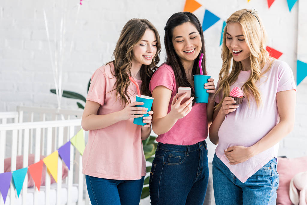 amigos multiculturais e mulher grávida olhando para o smartphone na festa do chuveiro do bebê
 - Foto, Imagem