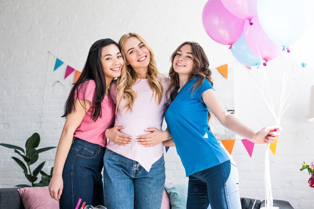 multicultural friends and pregnant woman posing with balloons at baby shower party - Foto, afbeelding