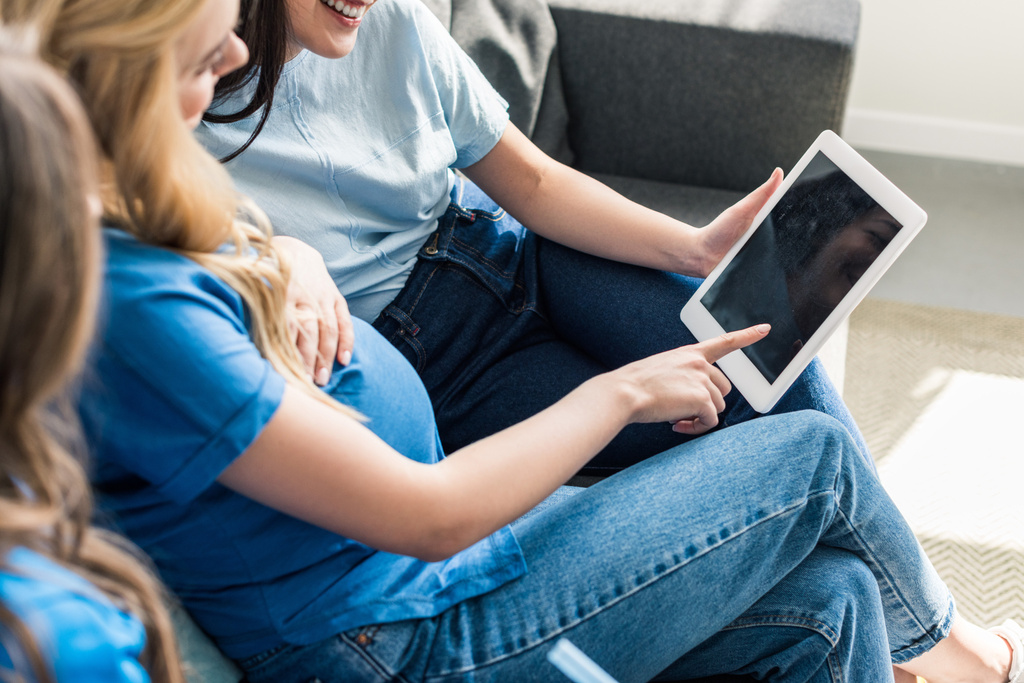 imagem cortada de amigos e mulheres grávidas usando tablet em casa
 - Foto, Imagem