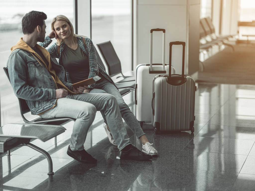 Glad female speaking with man in airport - Photo, Image