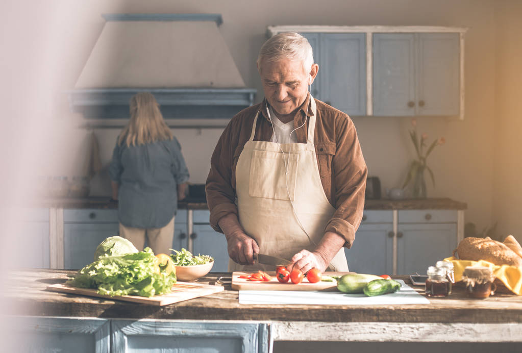 Fröhliches Senioren-Ehepaar kocht Mittagessen zu Hause - Foto, Bild