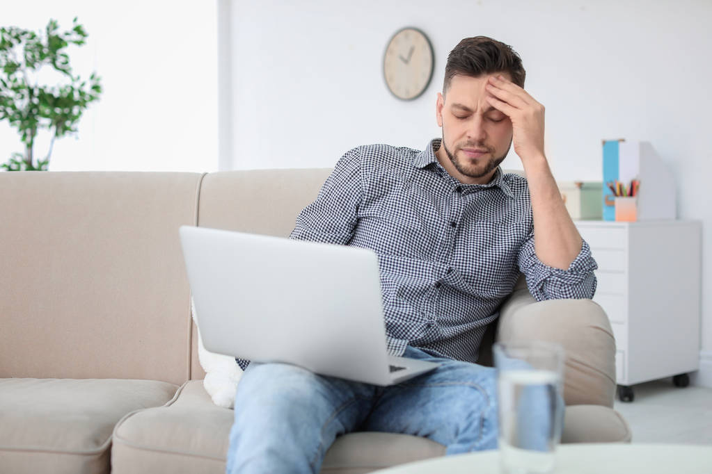 Mann leidet zu Hause unter Kopfschmerzen - Foto, Bild