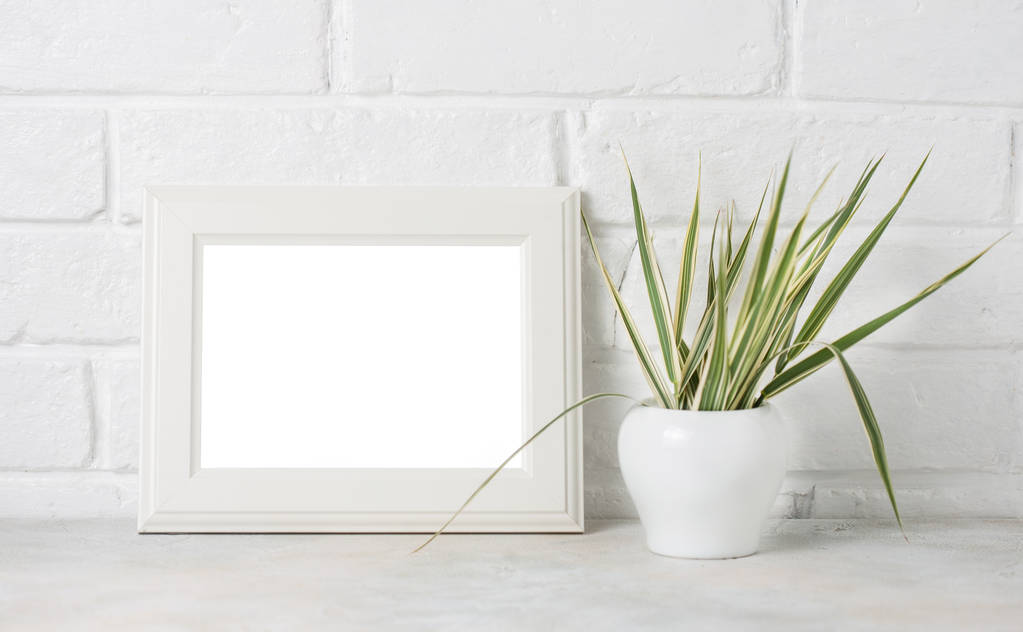 White wooden frame with copyspace and greenery on white Brick wall background. - Photo, Image