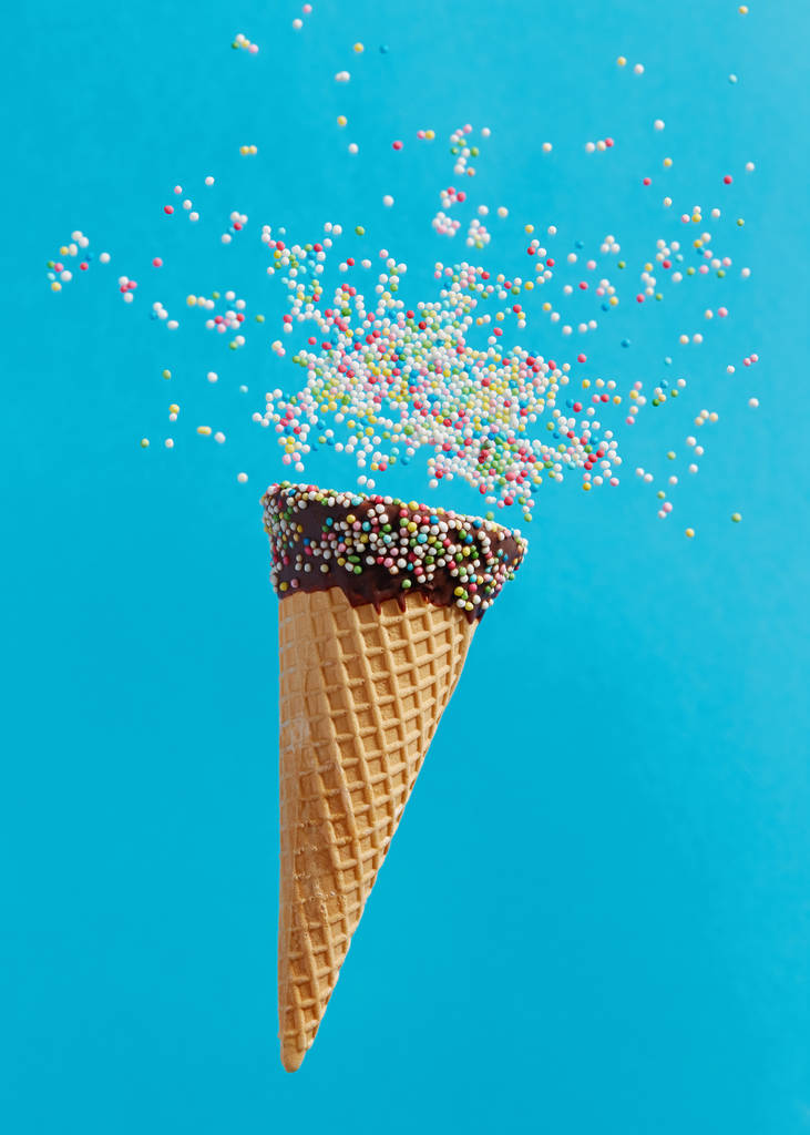 Конус мороженого с красочными брызгами на синем фоне
.  - Фото, изображение