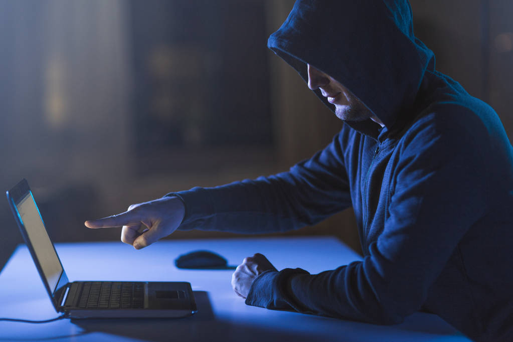 hacker apuntando a la computadora portátil en la habitación oscura
 - Foto, imagen