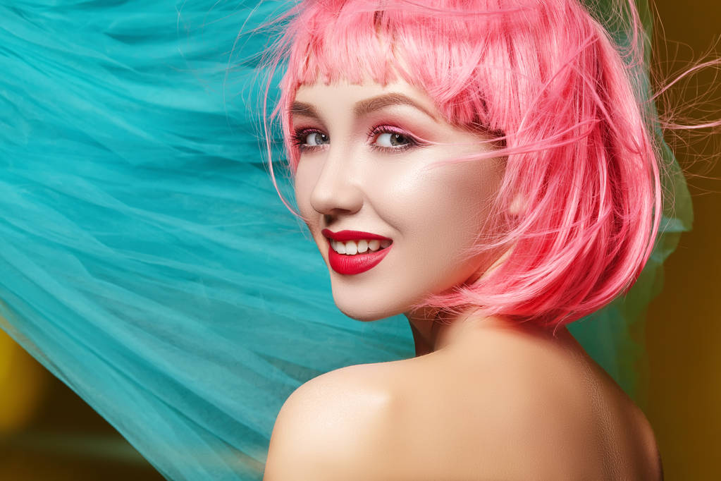 Mladá žena v růžové paruce. Krásný model s módní make-up. Jarní pohled. Sexy vlasy barva, střední účes - Fotografie, Obrázek
