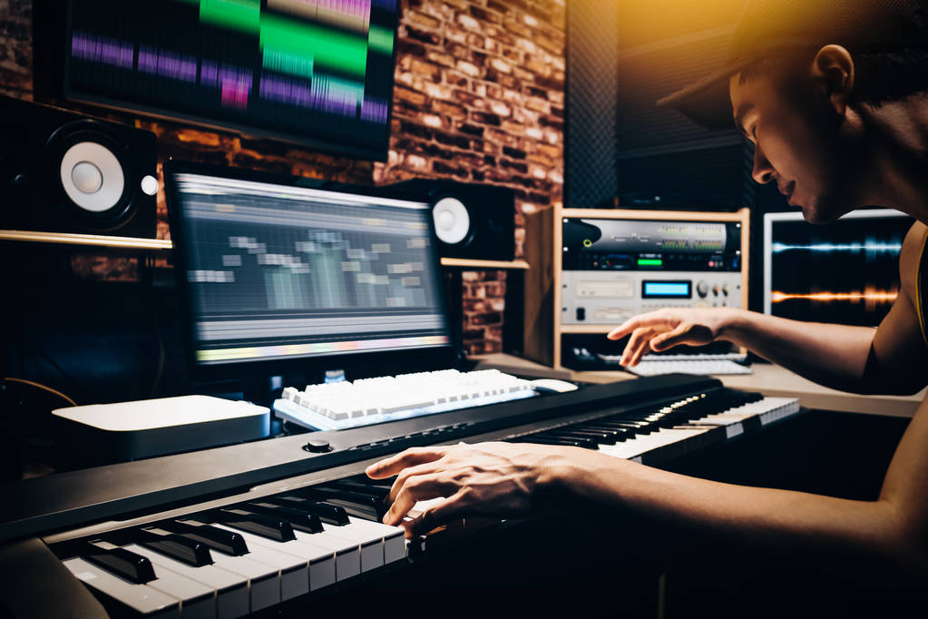 asiatique mâle arrangeur de musique mains composer chanson sur midi piano & équipement audio professionnel en studio d'enregistrement numérique
 - Photo, image