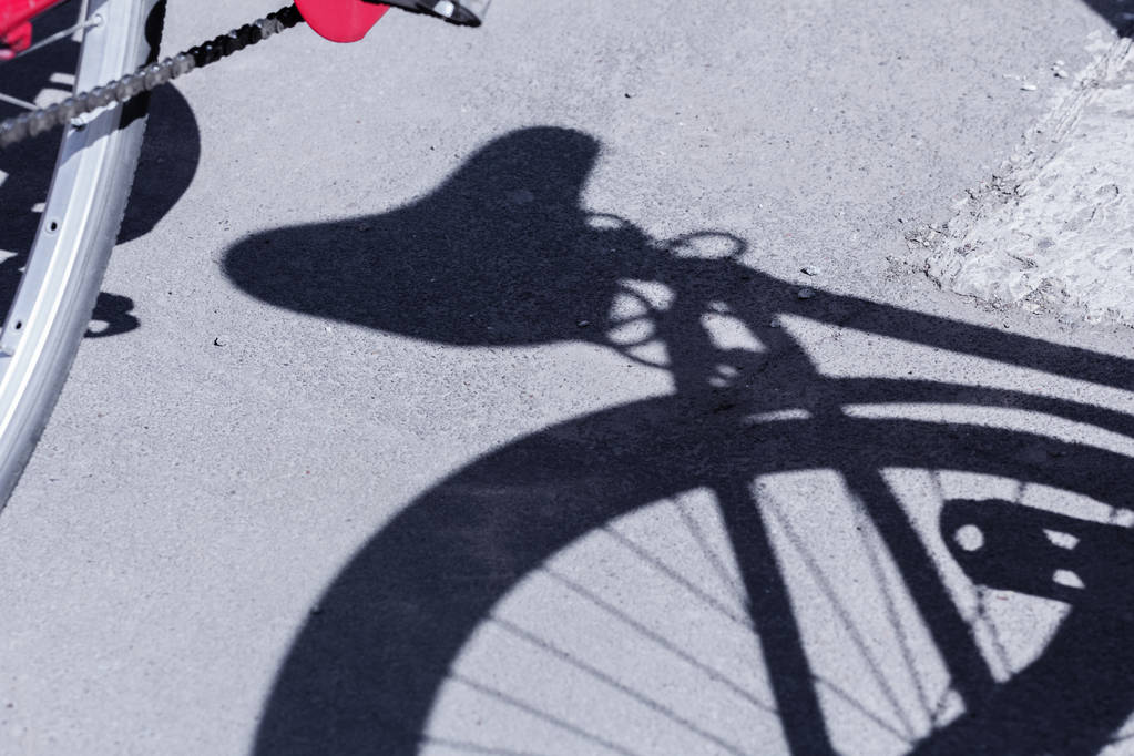 Schatten des Fahrrads auf dem Bürgersteig bei sonnigem Tag - Foto, Bild