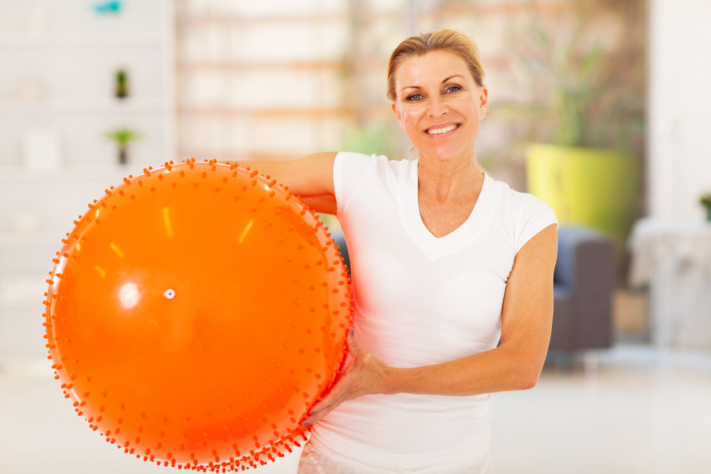 Fit mature woman holding exercise ball at home - Photo, Image