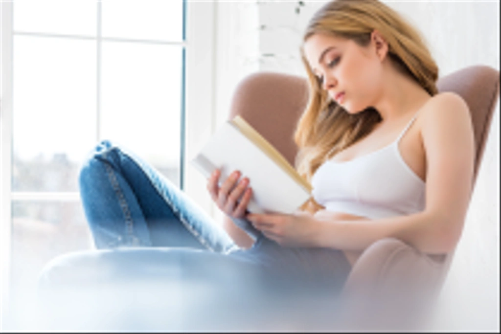blondi kaunis tyttö lukeminen kirja ja istuu nojatuoli
 - Valokuva, kuva