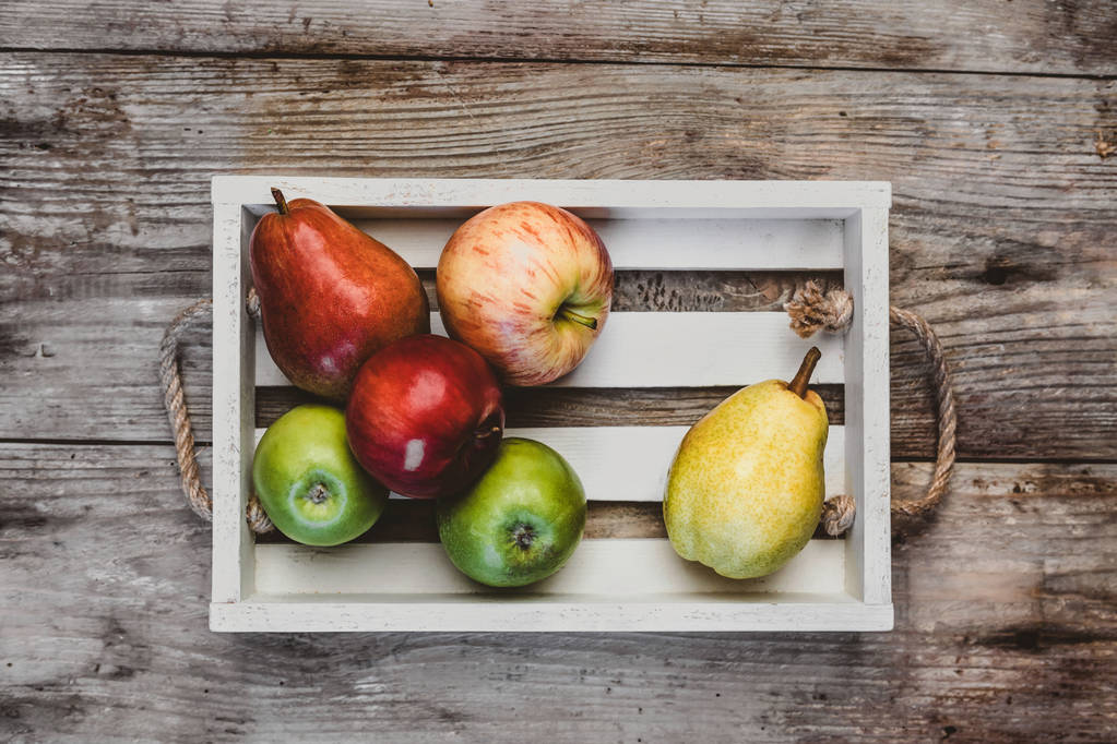 pohled z jablek a hrušek v dřevěné krabici na rustikální stůl - Fotografie, Obrázek