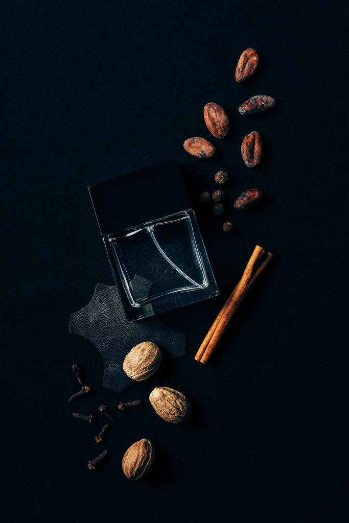 felülnézet parfüm körül a fűszerekkel, fekete üveg - Fotó, kép