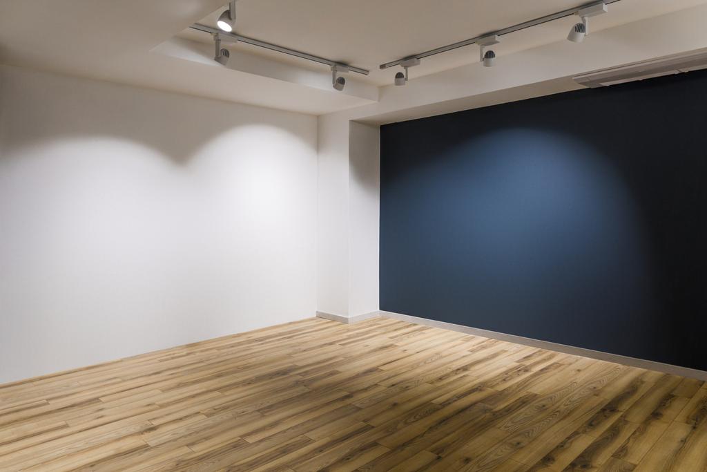 Chambre vide avec murs sombres et blancs et plancher en bois
 - Photo, image