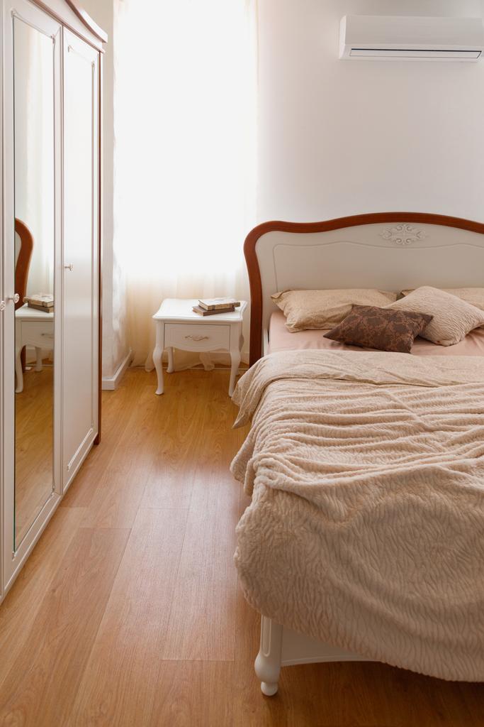 ミラー付きの居心地の良い寝室でベッドの上の光の寝具 - 写真・画像