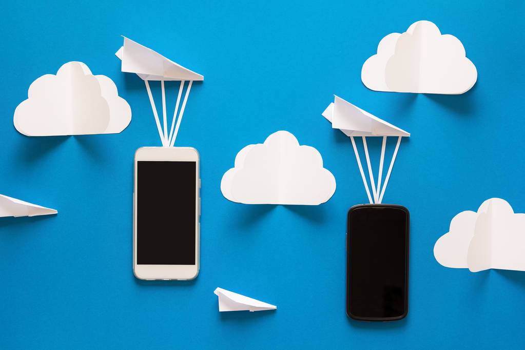 Concept de transfert de données. Le message passe. Deux smartphones mobiles et des avions en papier sur fond bleu. Origami. Découpe de papier
. - Photo, image