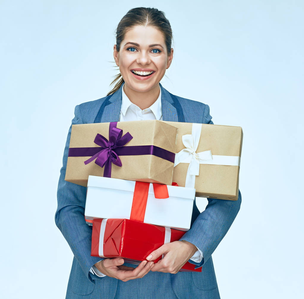 Улыбающаяся деловая женщина в костюме держит подарочные коробки
  - Фото, изображение