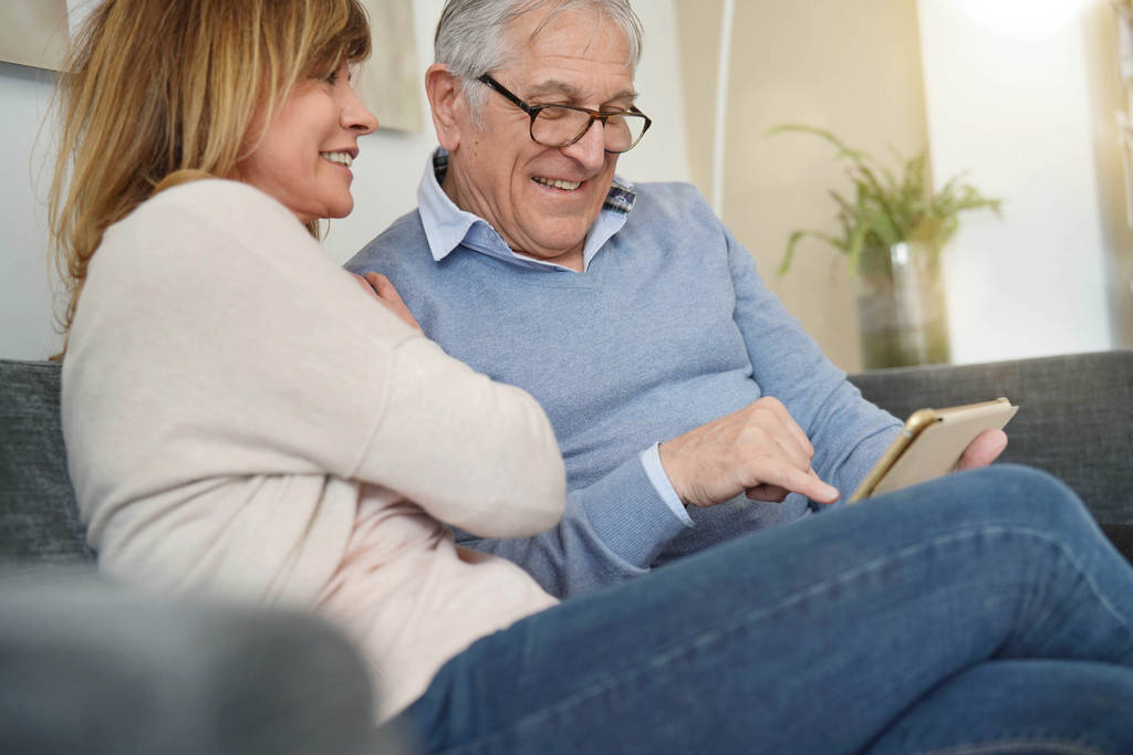 Senior couple in sofa websurfing on digital tablet - Photo, Image