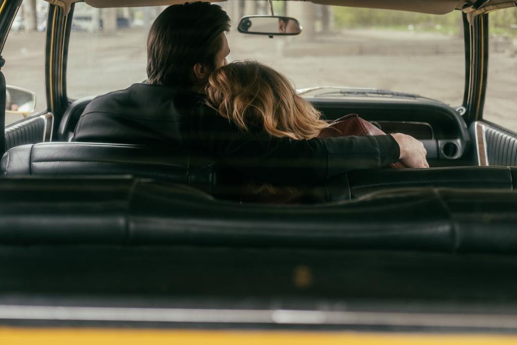 Widok z młoda para zakochanych, obejmując razem siedząc w samochodzie z tyłu - Zdjęcie, obraz