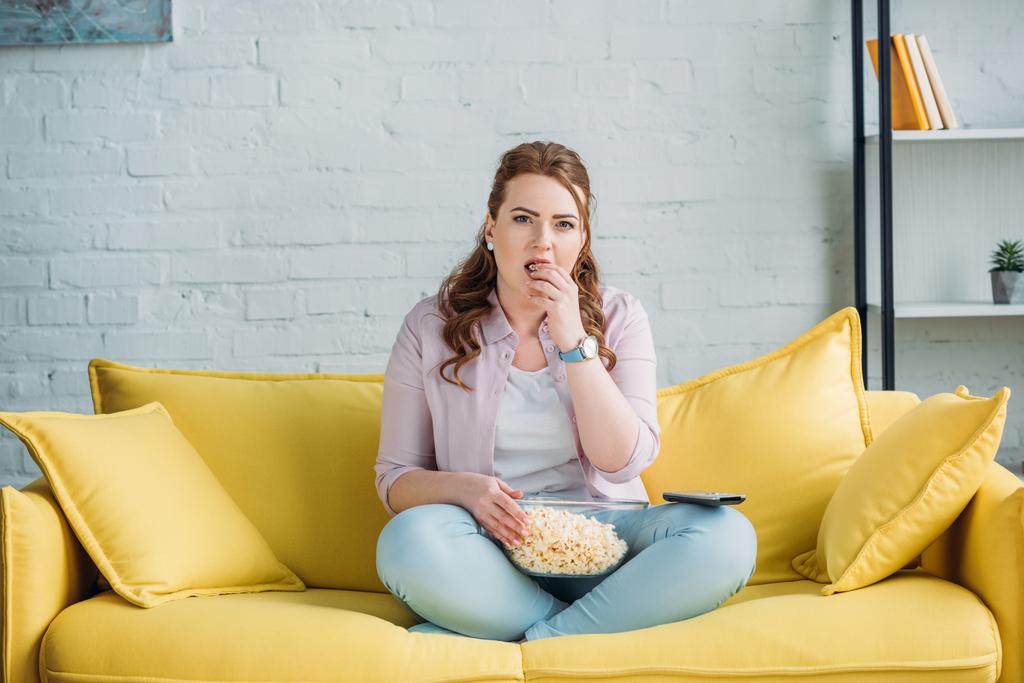 όμορφη γυναίκα βλέποντας ταινία και τρώγοντας ποπ κορν στο σπίτι - Φωτογραφία, εικόνα