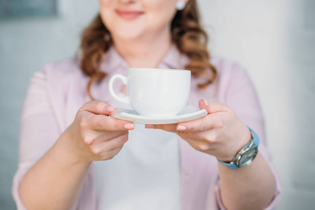 περικομμένη εικόνα της γυναίκας δείχνει Κύπελλο του καφέ στο σπίτι - Φωτογραφία, εικόνα