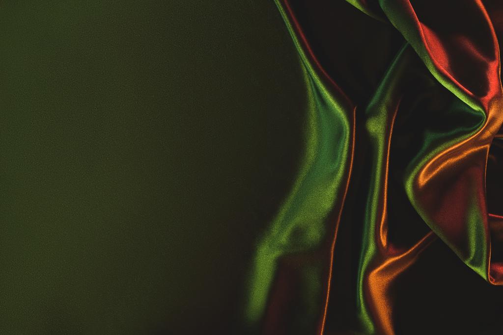zblízka pohled tmavě zelené pomačkané hedvábné látky jako pozadí - Fotografie, Obrázek