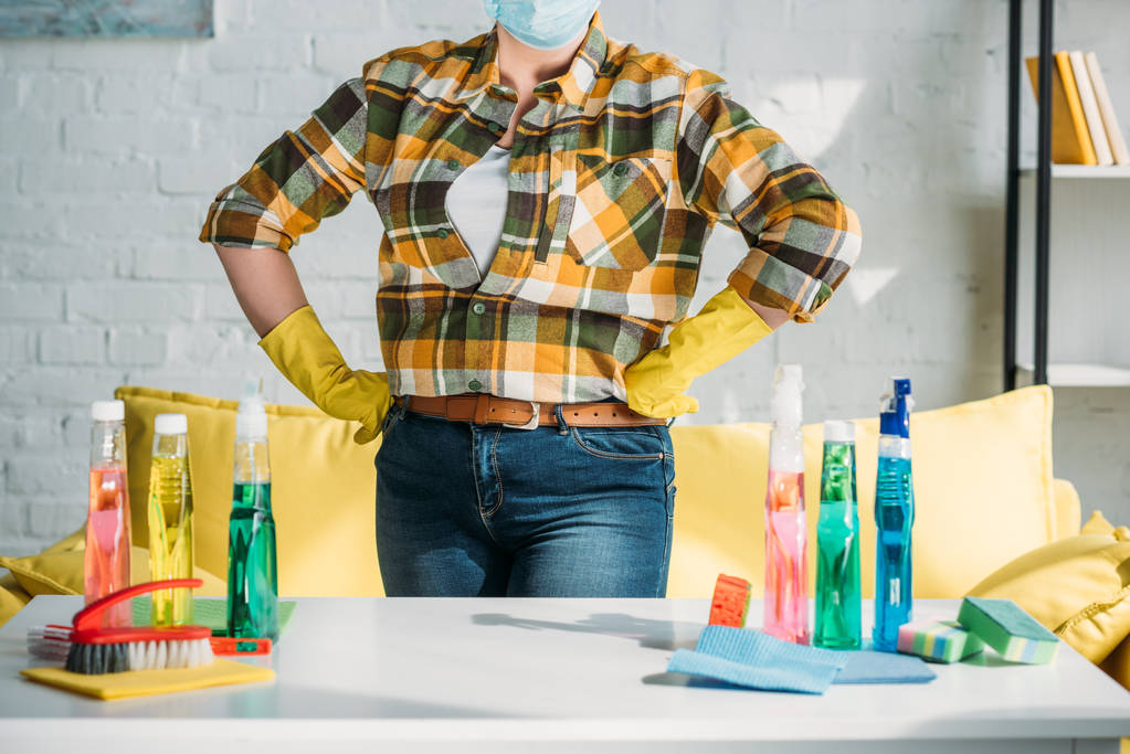 körülvágott kép nő közelében tisztítószerek otthon asztal  - Fotó, kép