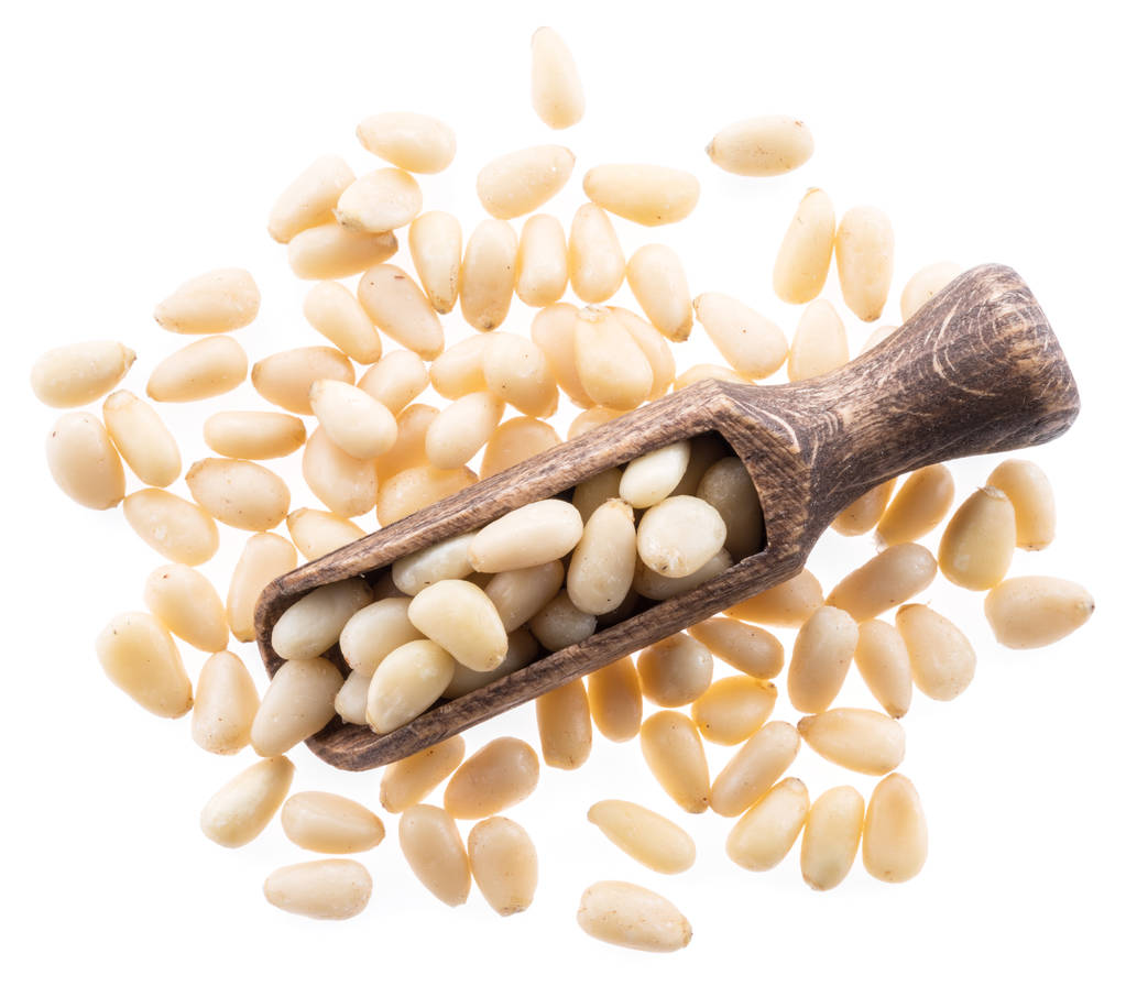 Pine nuts in the wooden scoop. White background. - Photo, Image
