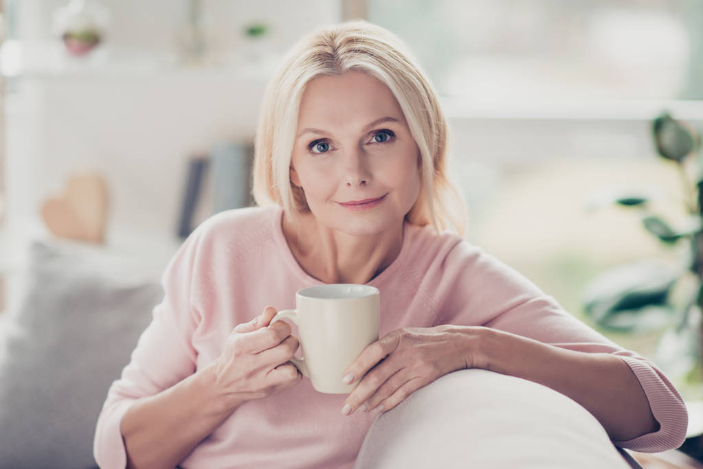 Сучасна, стильна, кавказька, у віці, жінка має чашку кави в
  - Фото, зображення