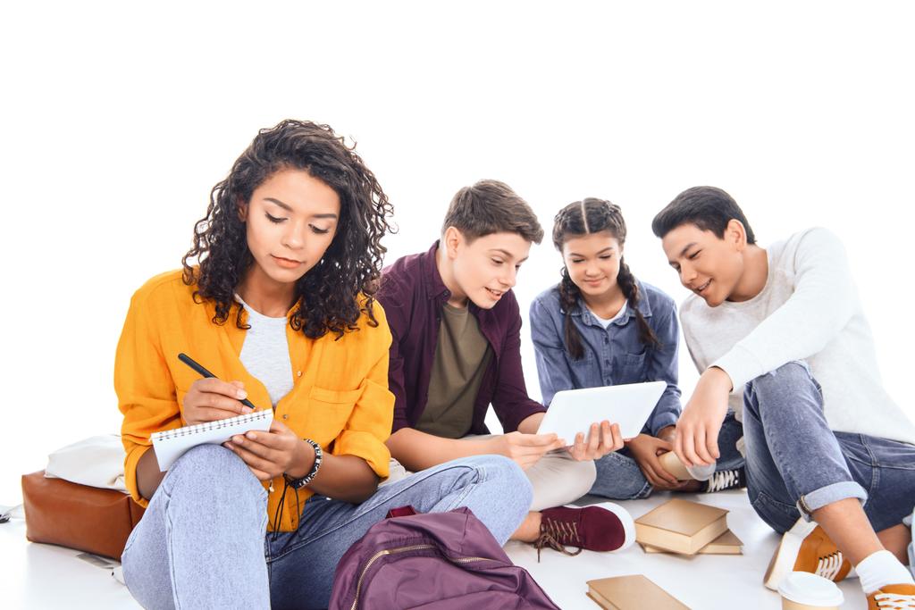 multiraciale studenten met rugzakken en -laptops geïsoleerd op wit - Foto, afbeelding