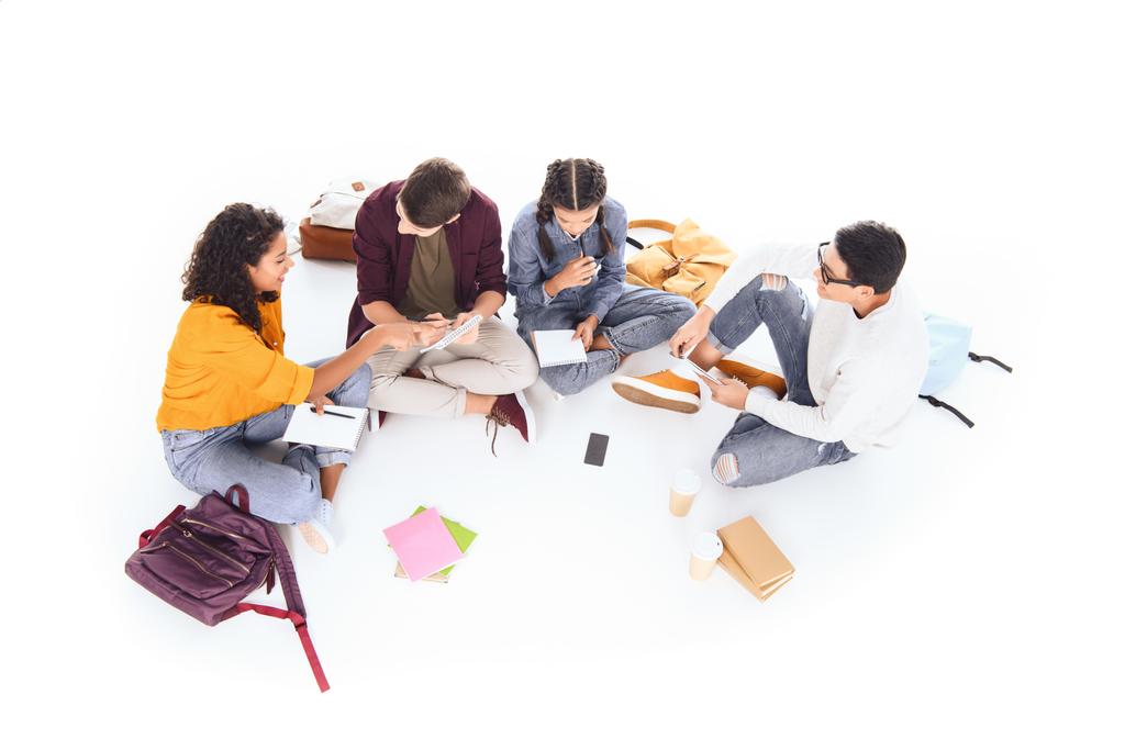 высокий угол зрения многорасовые студенты делают домашнее задание вместе изолированы на белом
 - Фото, изображение