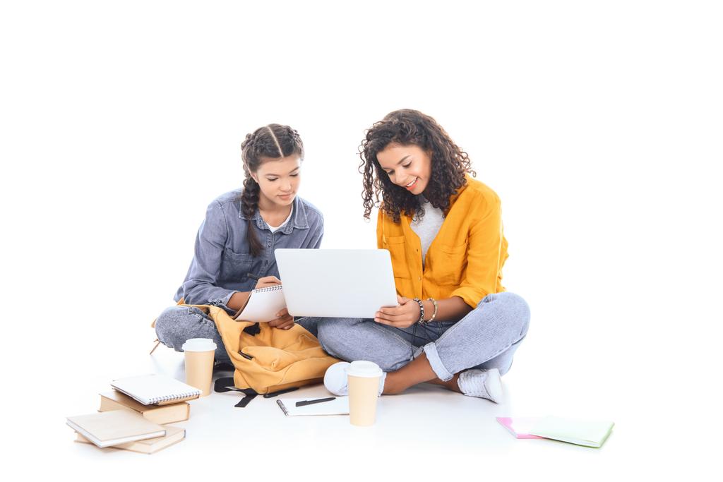 adolescentes multiculturais usando laptop juntos isolados em branco
 - Foto, Imagem