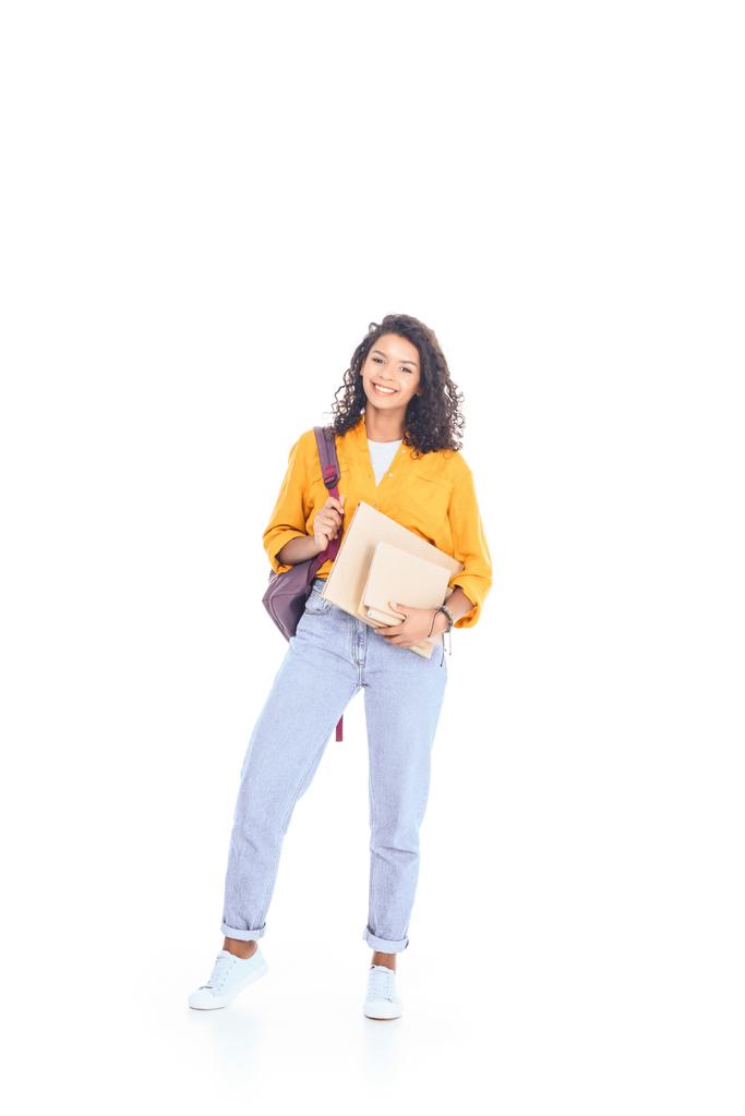 sırt çantası ve üzerinde beyaz izole kitap ile gülümseyen Afro-Amerikan öğrenci - Fotoğraf, Görsel