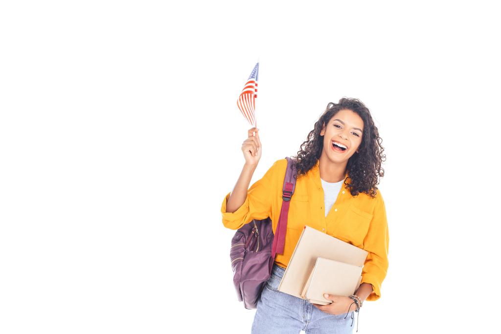 πορτρέτο της ευτυχισμένος Αφρικανικός Αμερικανός φοιτητής με αμερικανική σημαία, σακίδιο και βιβλία που απομονώνονται σε λευκό - Φωτογραφία, εικόνα