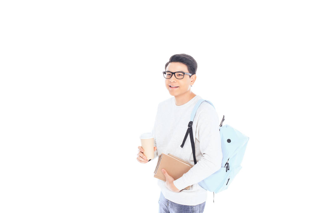 πορτρέτο της Ασίας φοιτητής με σημειωματάρια και καφέ να πάει απομονωθεί σε λευκό - Φωτογραφία, εικόνα